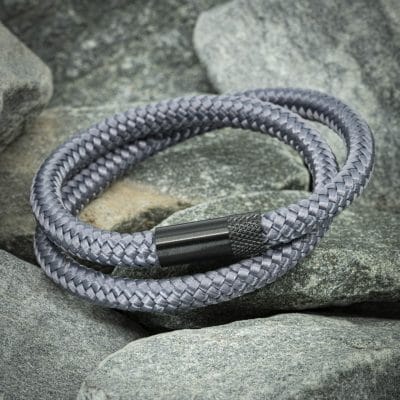 Navy™ Armband – Zwart Touw 4 een grijze touwarmband gewikkeld op rotsen